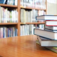 stack of books on a table in a library