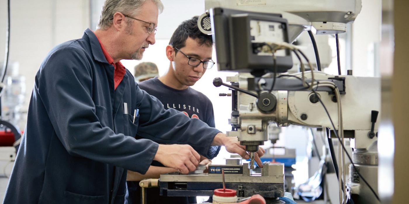 Kerry Smith, division chair of Professional and Technical Careers, assists a student with manufacturing equipment. Photo courtesy of Davidson-Davie Community College.