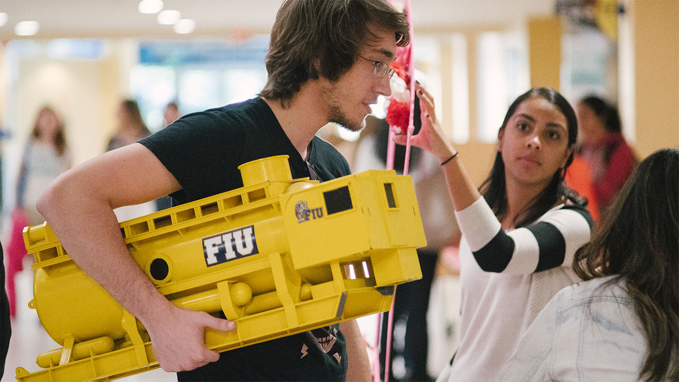 Aquarius Reef Base, seen here as a model traveling across campus with a marine biology student, is the world’s only underwater research lab used by scientists hailing from all across the globe to study marine ecosystems, test new underwater technology, and train divers and astronauts