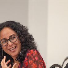 A woman smiles while speaking on a panel